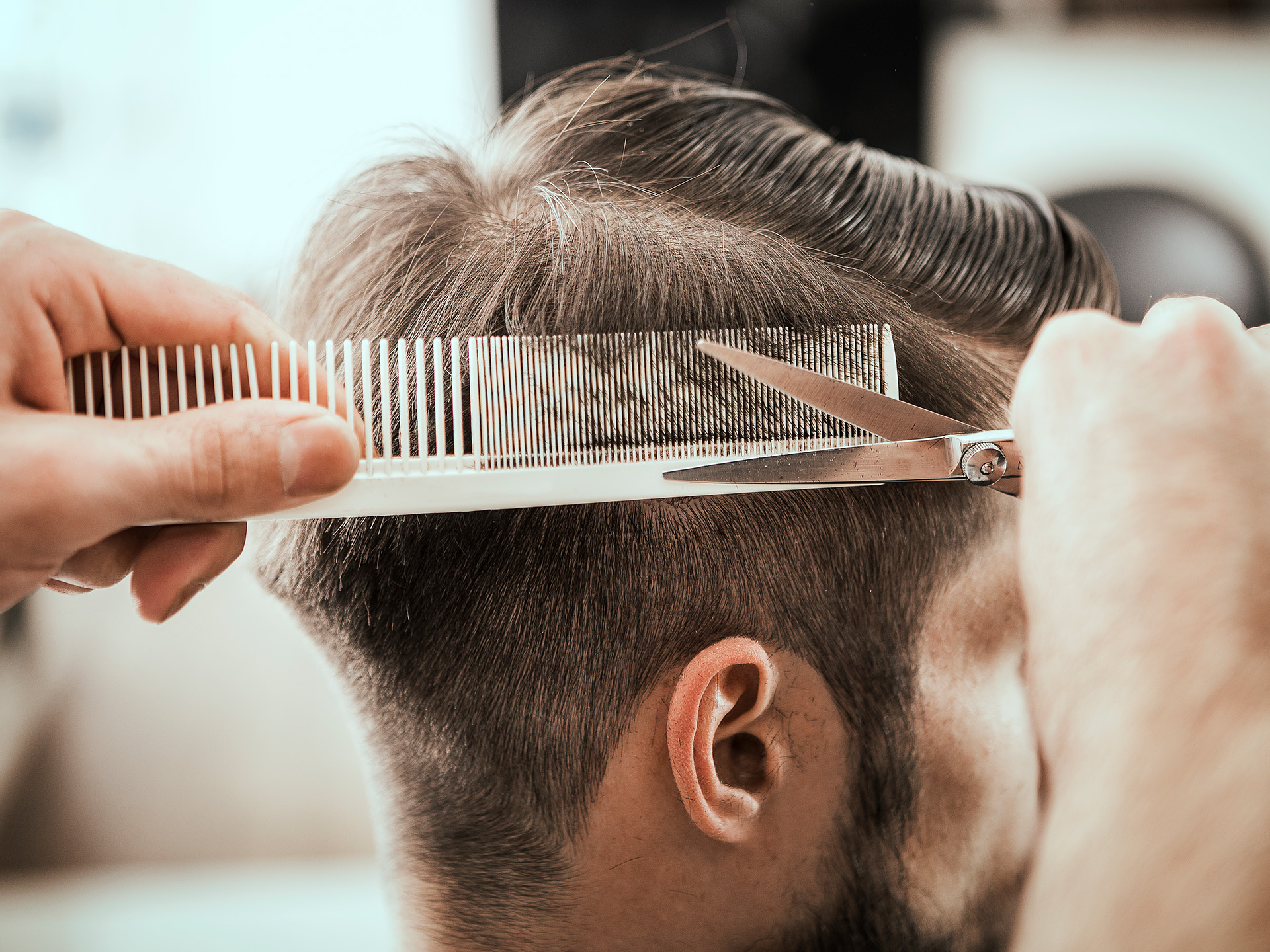 Friseur schneidet Mann die Haare